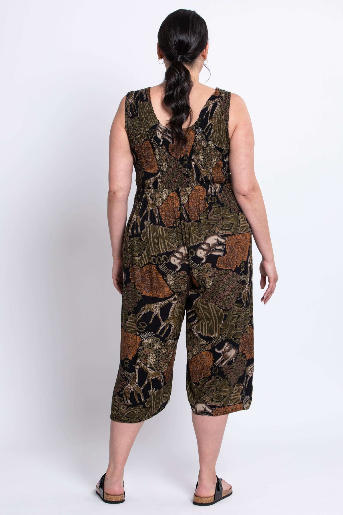 Back view of model wearing a sleeveless, wide-leg jumpsuit with animal print accents