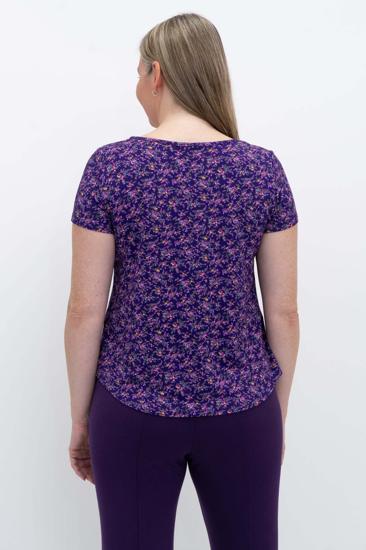 Back view of model wearing purple floral Ritzy Short Sleeve Top