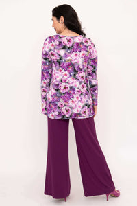 Back view of model in long sleeve purple floral tunic and plum pants