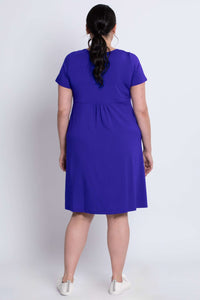Back view of a model showing the fit of a royal purple dress with short sleeves