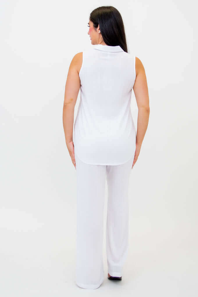 Back view of woman in sleeveless white tank top and wide-leg white pants