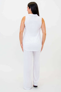 Back view of woman in sleeveless white tank top and wide-leg white pants