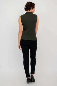 Back view of woman in sleeveless olive-green mock neck sweater and black pants