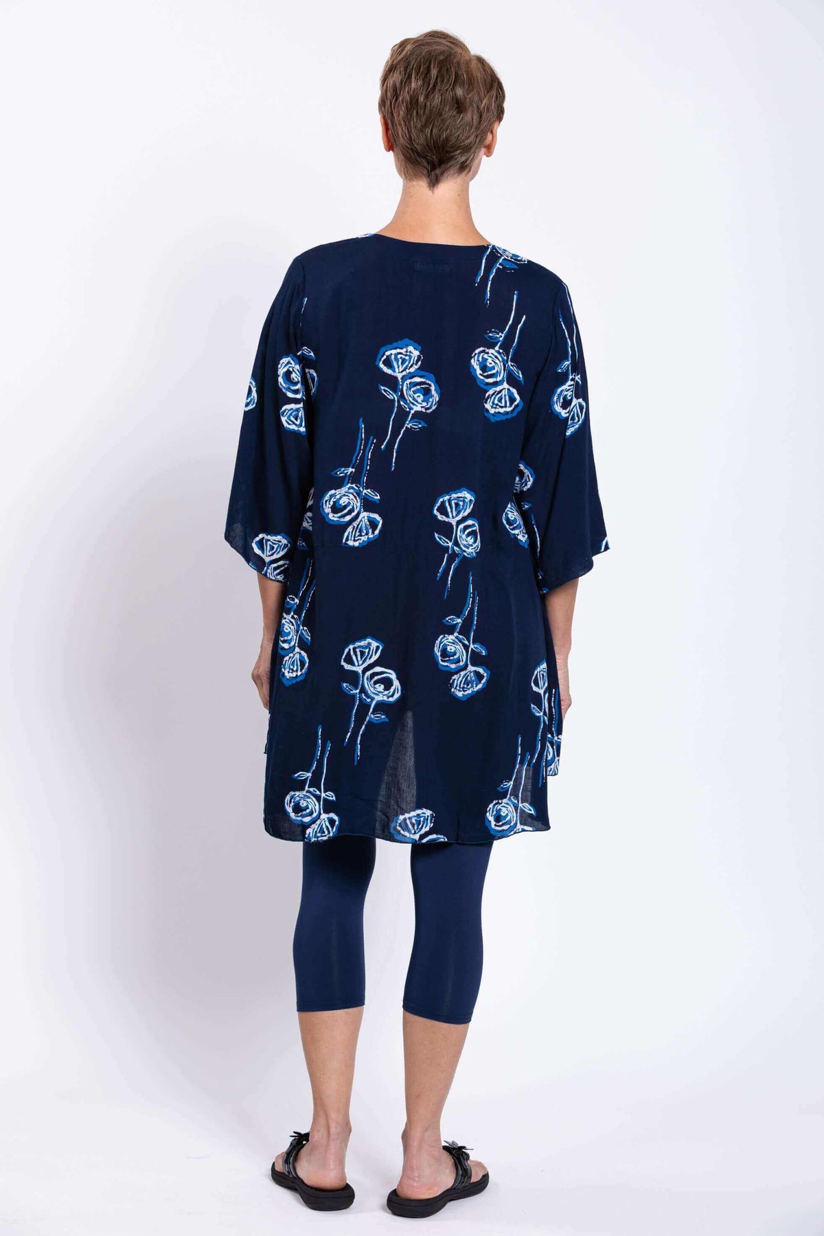 Back view of woman wearing navy Darla floral tunic blouse showing length and flow