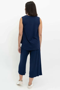 Back view of a woman in a sleeveless navy bamboo top and matching pants