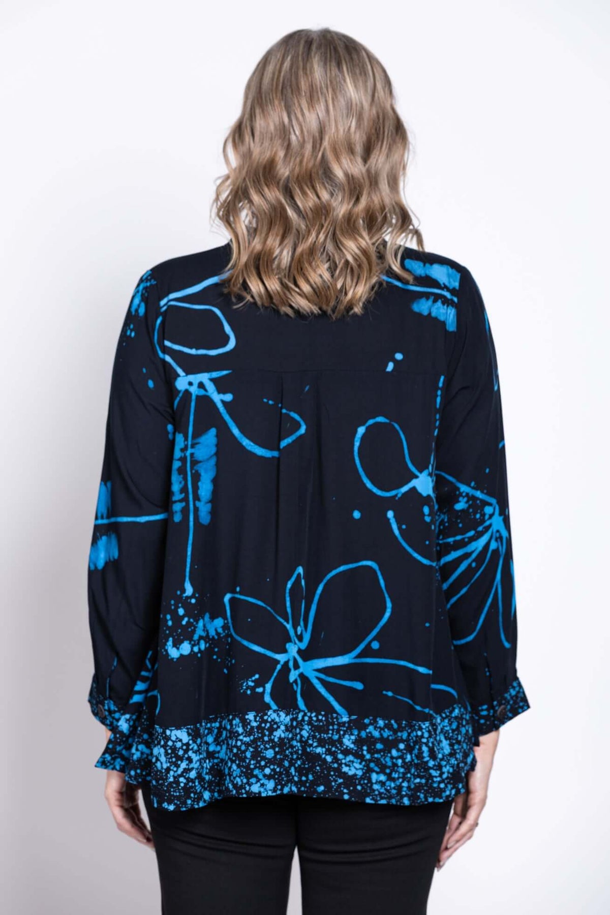 Back view of a woman wearing a navy batik print blouse with blue floral patterns