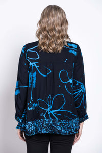 Back view of a woman wearing a navy batik print blouse with blue floral patterns
