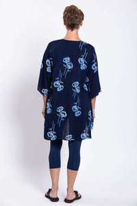 Back view of woman wearing Darla tunic blouse with blue floral print