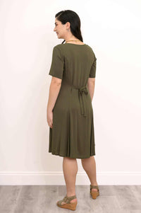 Back view of woman in olive princess seam dress with tie belt