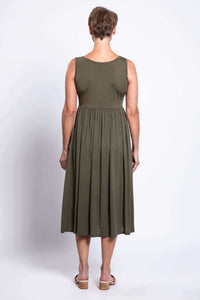 Back view of woman in olive empire waist midi dress with short hair