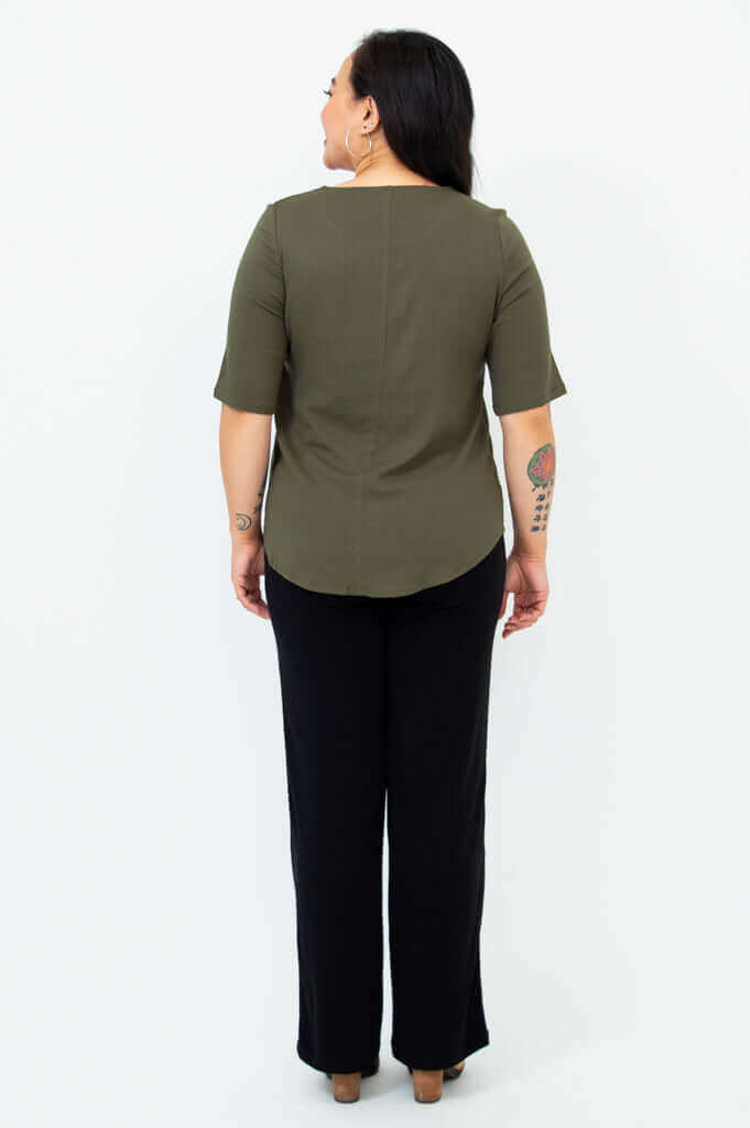 Back view of woman in olive green blouse with shirt tail hemline