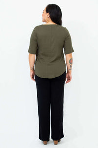 Back view of woman in olive green blouse with shirt tail hemline