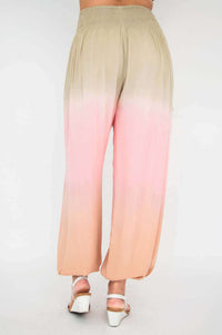 Back view of ombre boho pants, elastic waistband and flowing peach-pink gradient fabric