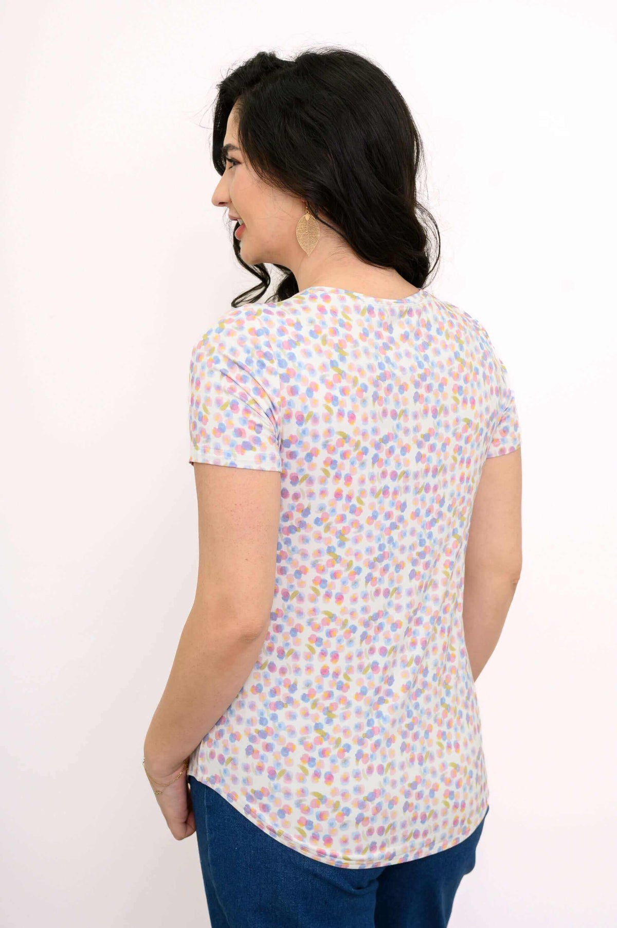 Back view of woman in pastel confetti short sleeve tee, showing rounded hem