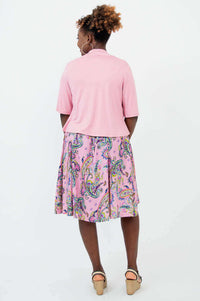 Back view of woman wearing a light pink cropped jacket and pink paisley dress