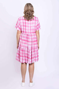 Back view of woman in pink check flounce tiered dress with short sleeves