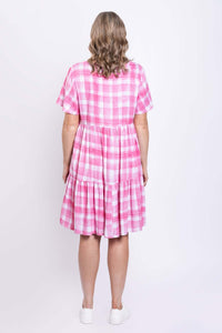 Back view of woman in pink gingham check tiered flounce dress