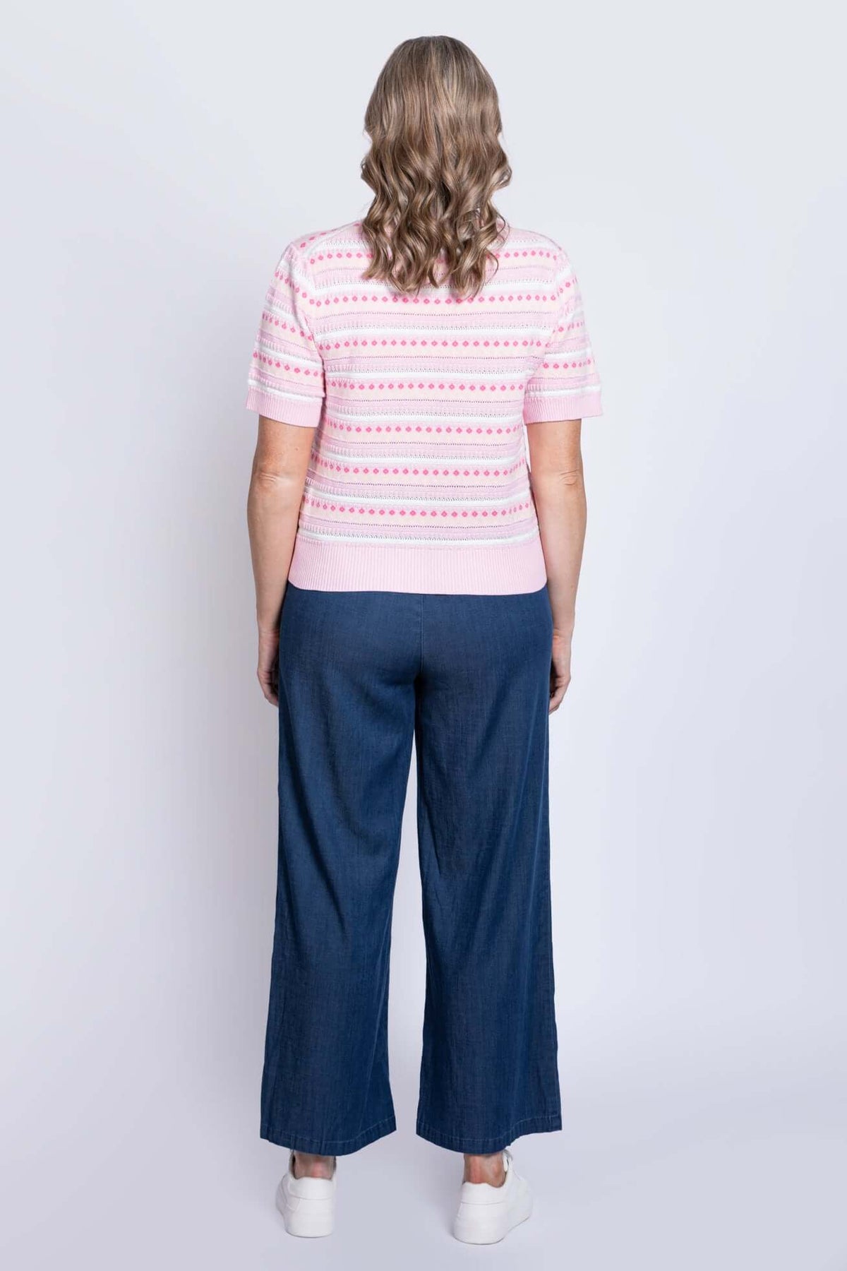 Back view showing ribbed hem and short sleeves of pink patterned sweater