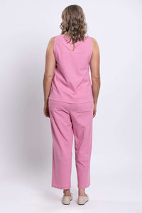 Woman in pink tank top and pants, back view showing button closure detail