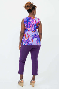 Back view of a woman in a purple and pink floral V-neck tank top and purple pants