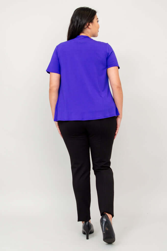 Back view of model wearing a purple short sleeve open jacket and black pants