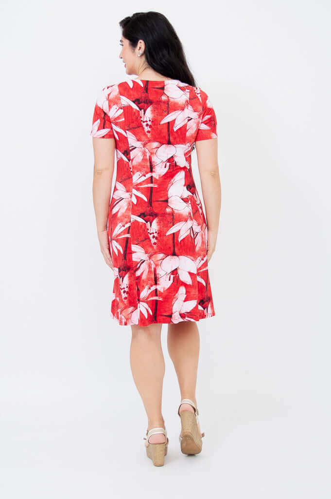 Back view of a woman in a short-sleeved red dress with white floral pattern