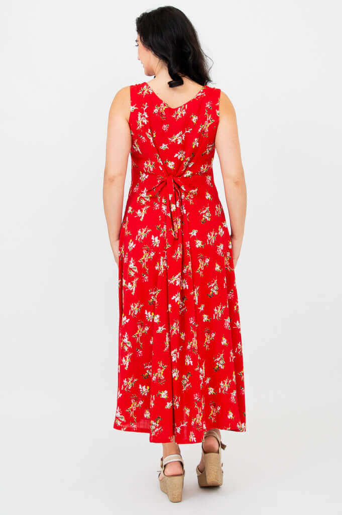 Back view of woman in red floral maxi dress with tie detail at the waist