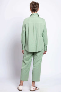 Back view of woman in light green relaxed fit shirt and matching pants