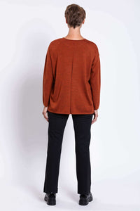 Back view of woman wearing rust Merino wool relaxed fit sweater