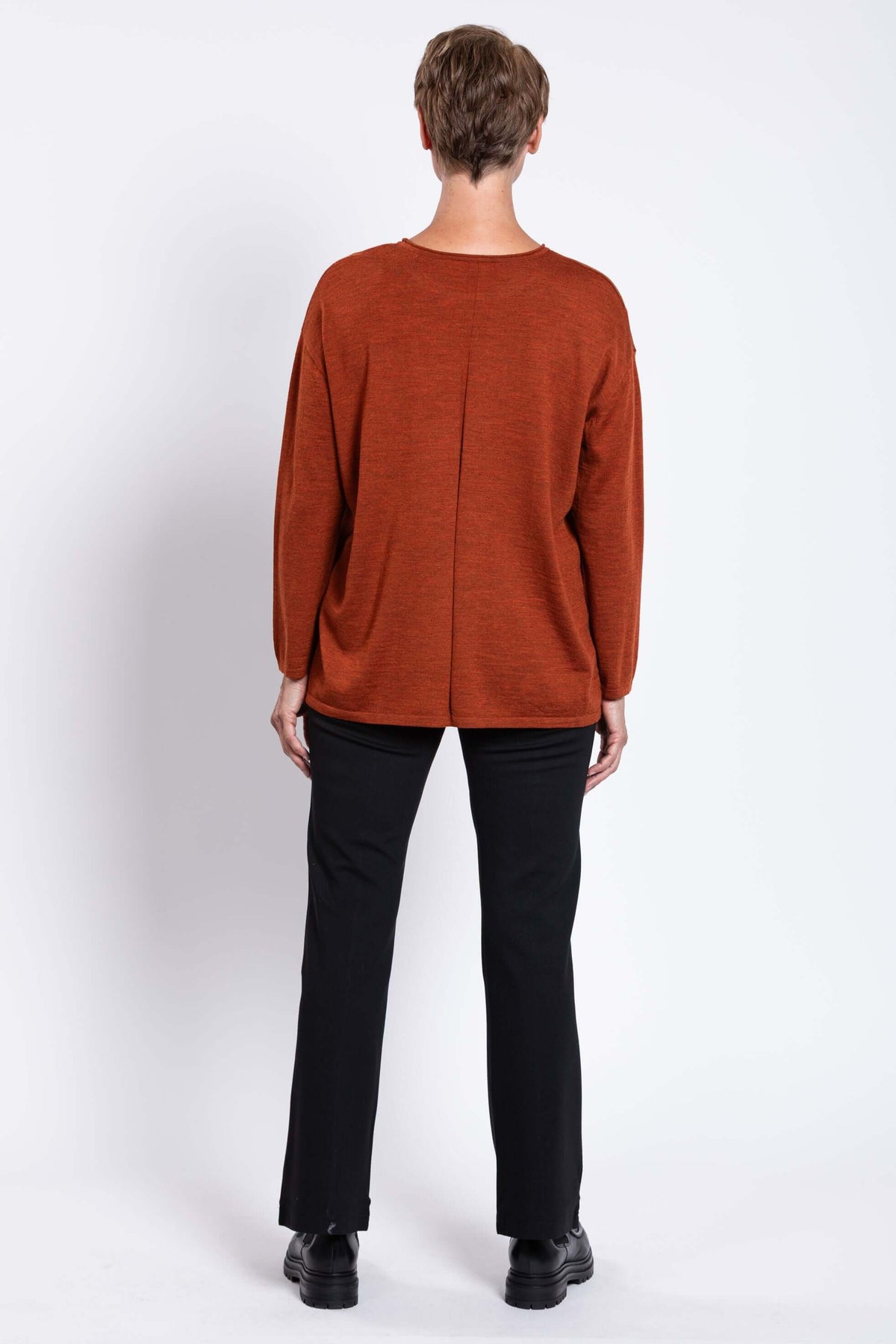 Back view of woman wearing rust red boxy fit Merino wool sweater