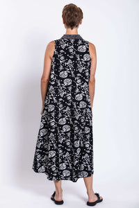 Rear view showing the back of a sleeveless black dress with white abstract floral designs