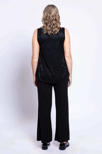 Back view of woman in sleeveless black lace tank top and black pants