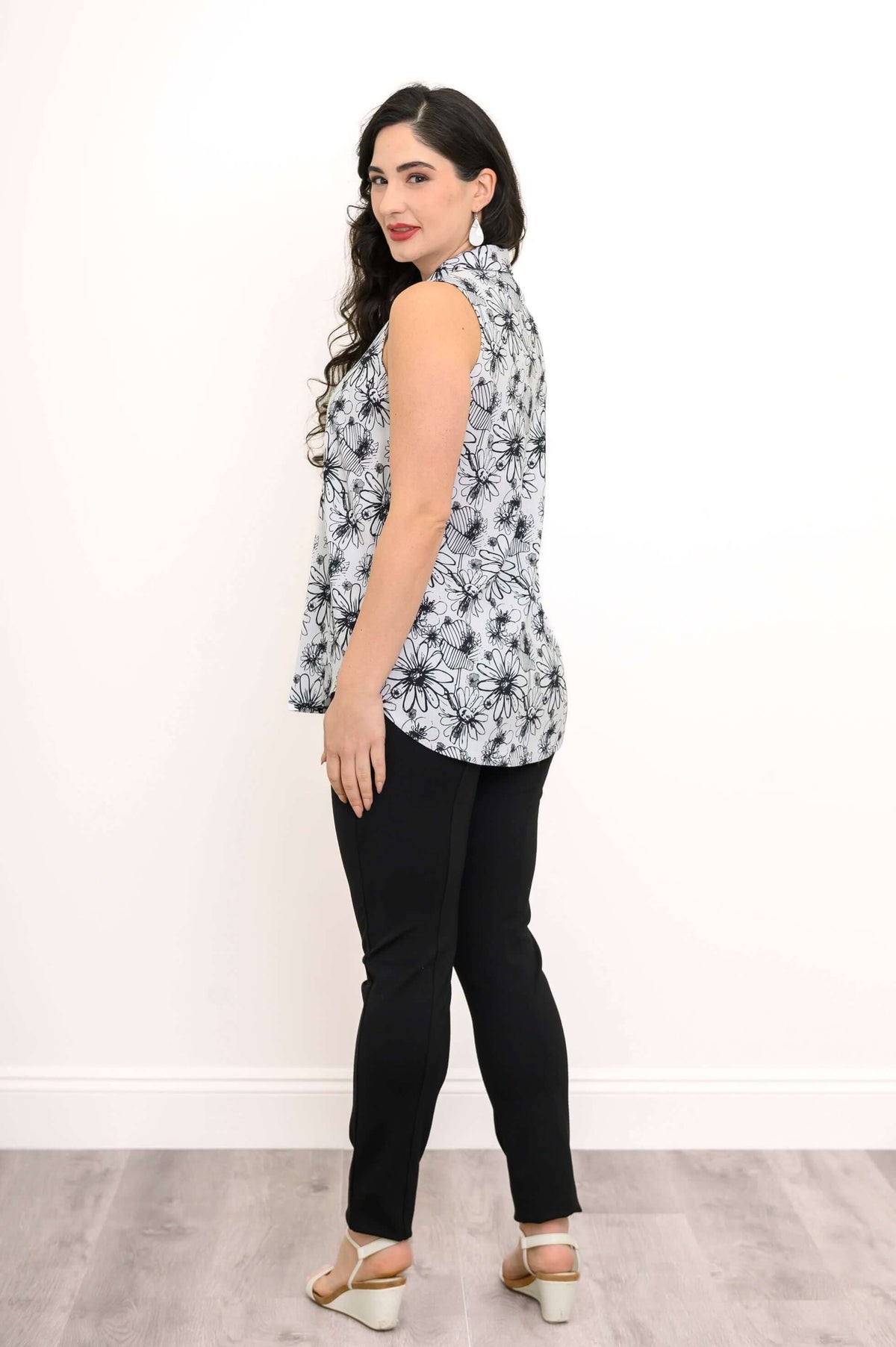 Back view of sleeveless floral zip tank top with black pants