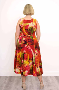 Back view of woman wearing sleeveless midi dress with tie-back waist and colorful abstract print