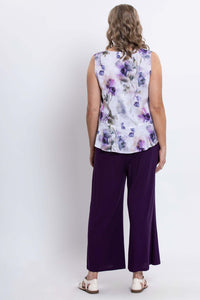 Back view of the woman modeling a sleeveless purple floral tank top and purple wide-leg pants