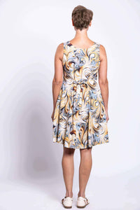 Back view of swirl print sleeveless dress showing tie-belt detail