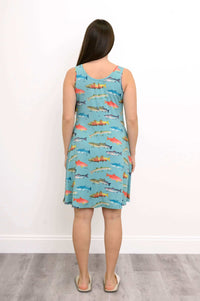 Back view of woman in turquoise sleeveless dress with detailed fish design