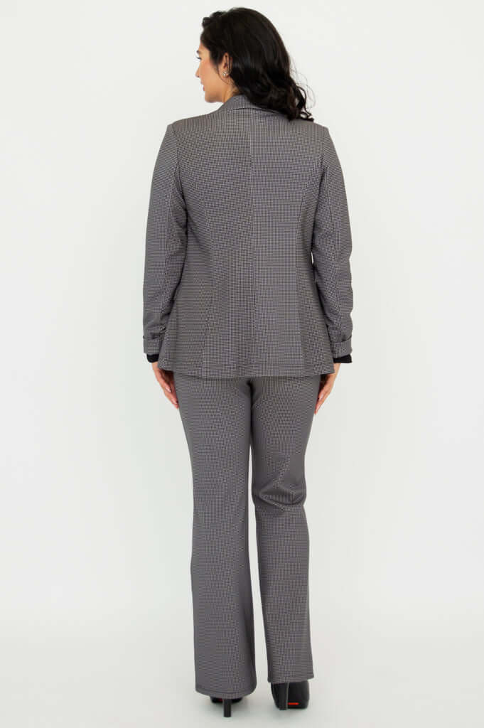 Back view of a woman wearing a tailored checkered blazer and matching pants