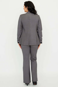 Back view of a woman wearing a tailored checkered blazer and matching pants