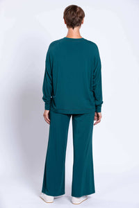 Back view of woman wearing teal bamboo crew neck top and wide leg pants