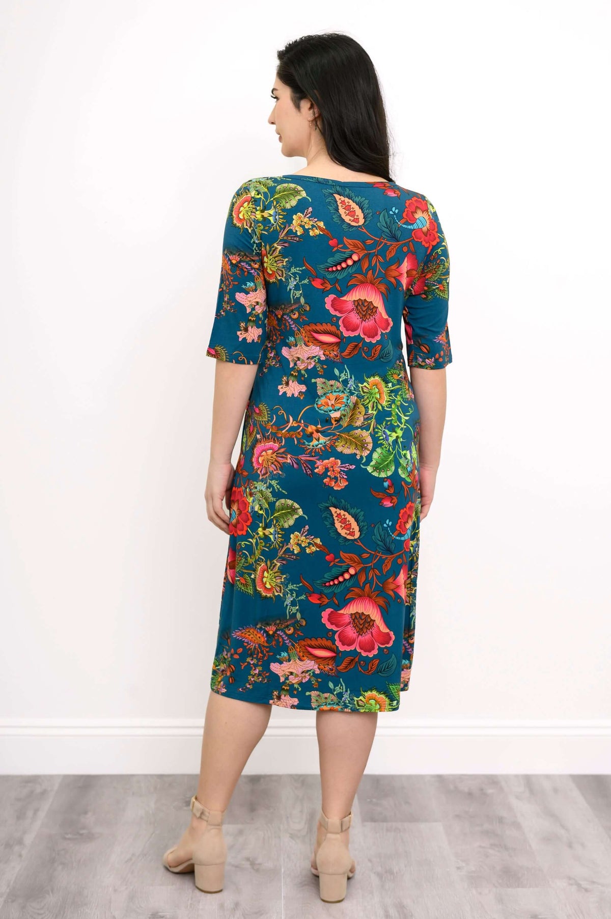Back view of a woman in a teal bamboo dress with colorful floral design