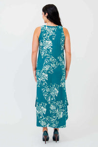 Back view of model wearing teal sleeveless midi dress with white floral print