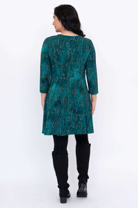 Back view of model in teal tunic with abstract symbols, showing sleeve and skirt detail
