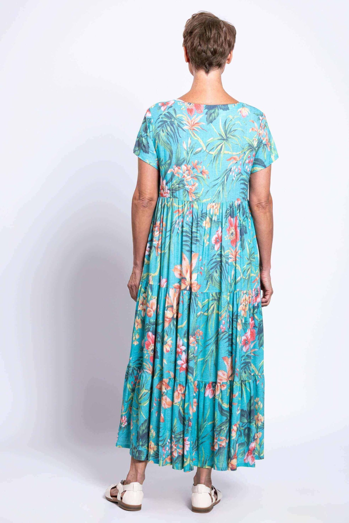 Back view of woman in turquoise floral maxi dress with short sleeves