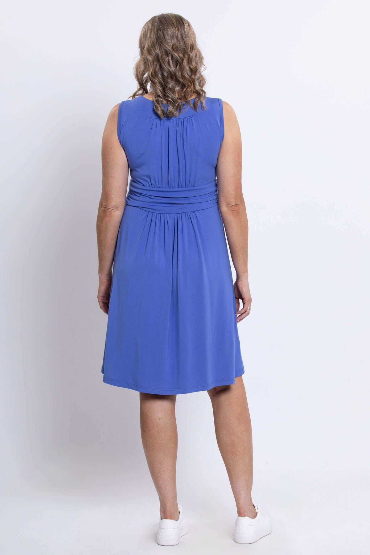 Back view of woman wearing the violet ruched dress highlighting gathers and waistband