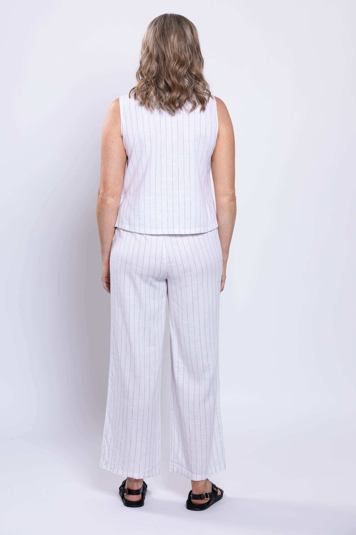 Back view of model wearing white striped cropped tank and wide-leg pants