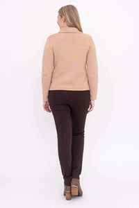 Back view of woman in beige cardigan and brown pants