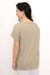 Back view of woman in beige dolman sleeve boatneck tee