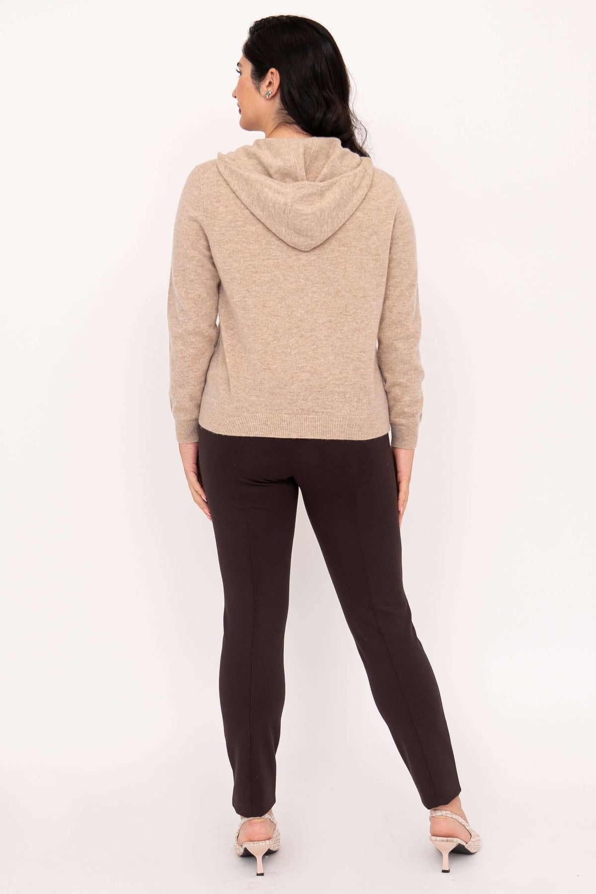 Back view of woman in beige hoodie with hood down