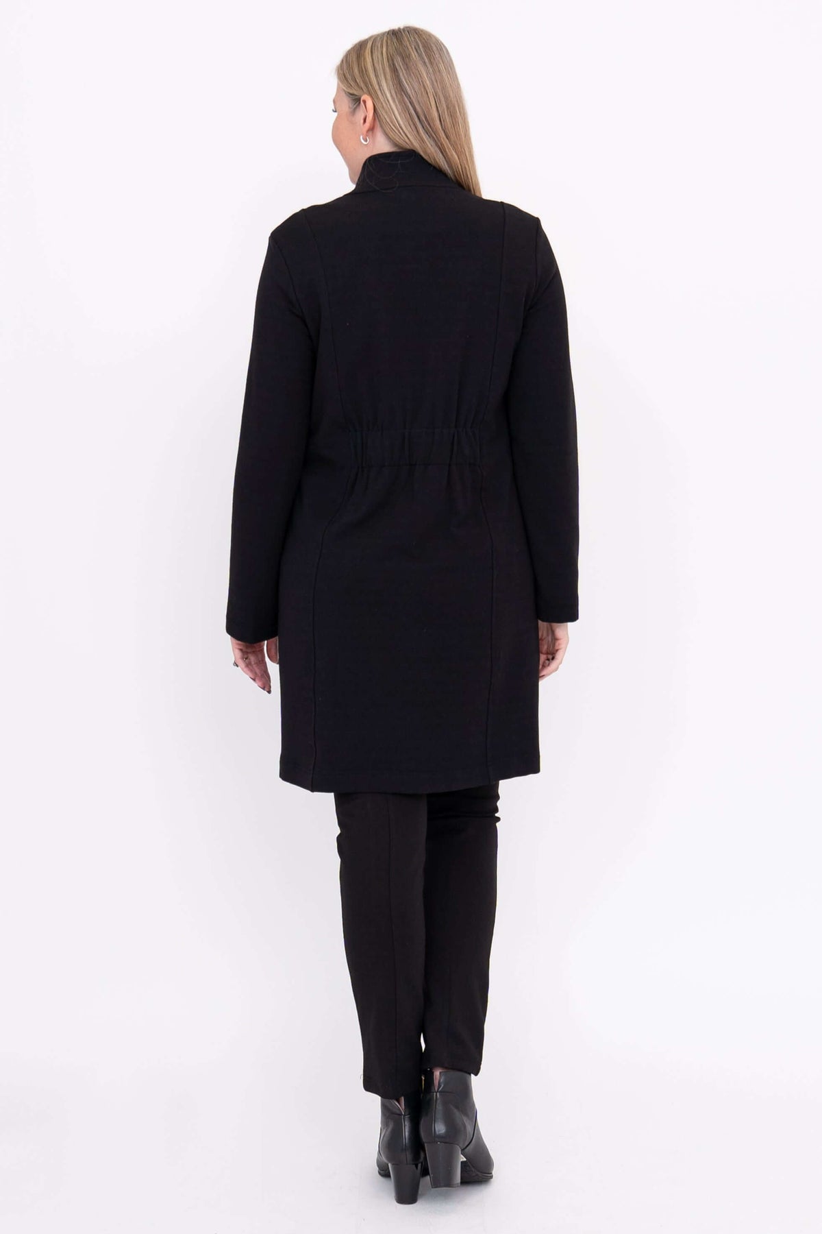 Back view of woman in black coat showing gathered waist detail